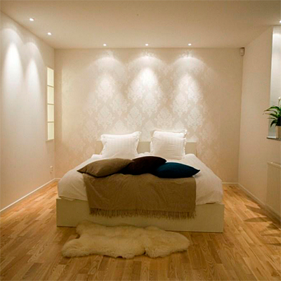 Sovrum med downlights som ger släpljus på väggen